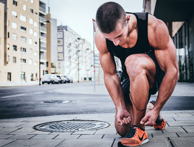 A runner tying his shoes
